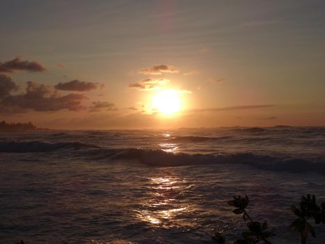 Beautiful Sunset over the ocean with waves moving to shore on the North Shore of Oahu.    