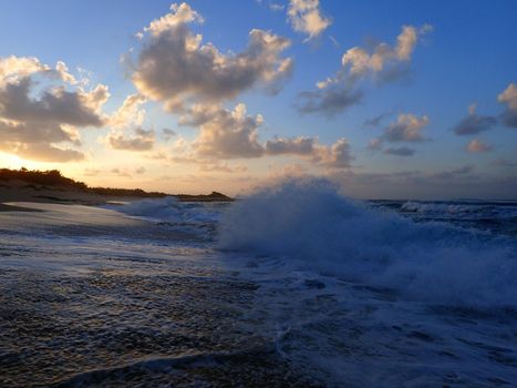 Waves break and crash towards the Hanakailio Beach with dramatic blue-pink cloudy skyline at dusk on the North Shore of Oahu, Hawaii.  February 2016.