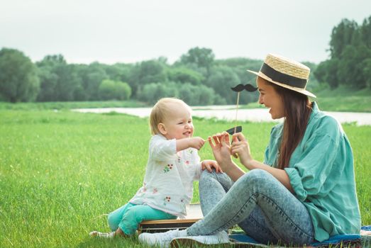 Mother is playing with baby girl in the park. High quality photo