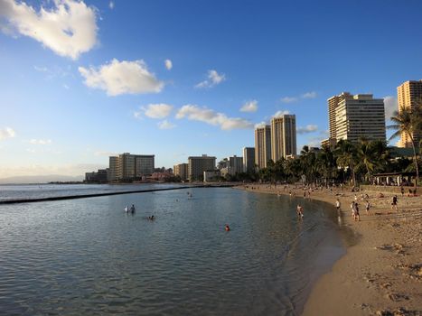 WAIKIKI - FEBRUARY 7: People play in water and beach in Waikiki at dusk on  February 7, 2016.