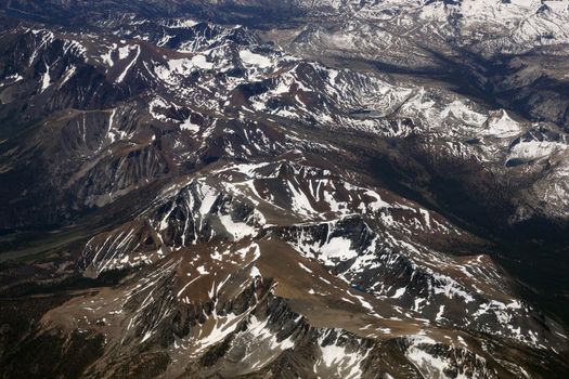 Aerial view of Top of sierra nevada mountains during the summer with a small amount of snow still left on the mountains.                               