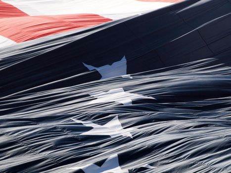 Giant USA flag unraveling puffing in the air with stars and stripes.