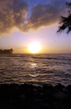 Beautiful Sunset over the ocean with waves moving to shore on the North Shore of Oahu.    