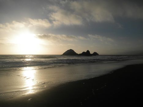 Sunset On Ocean Beach with Seal Rock in the Distance reflecting on the water in San Francisco.