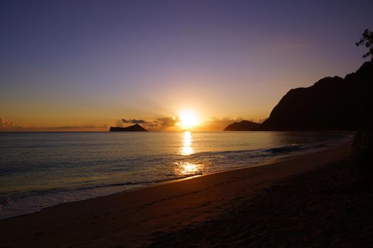 Early Morning Sunrise on Waimanalo Beach on Oahu, Hawaii over Rock Island bursting through the clouds. 2013.