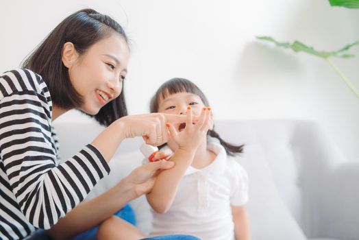 Mom paints nails to daughter