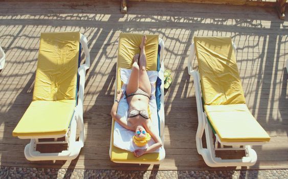 young woman sunbathing at the sea terrace . High quality photo