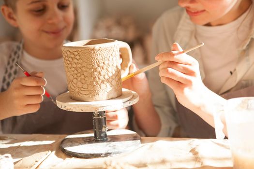 Close up of a ceramic mug mother and son are making together at art workshop