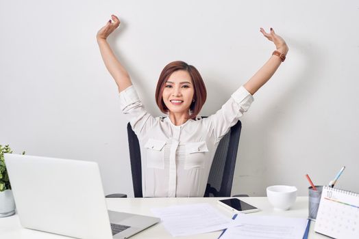 Satisfied woman relaxing with hands behind her head. Happy smiling employee after finish work, reading good news, break at work, girl doing simple exercise, relieve muscle stress, feeling well