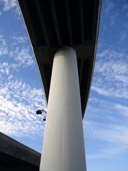 Highway overpass on large pillars towers in the sky filled with clouds  in San Francisco Mission Bay area in California.