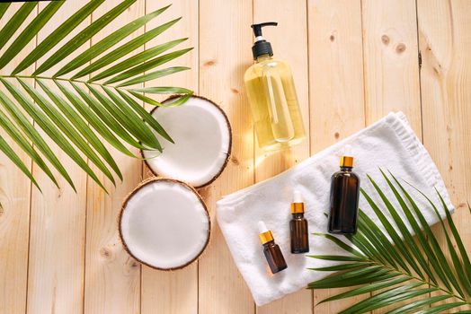 Cracked coconut and a bottle of oil on the table - spa, skincare, haircare and relaxation concept 