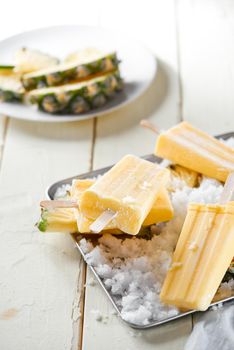 Homemade popsicles with lemon and mint on a wooden table