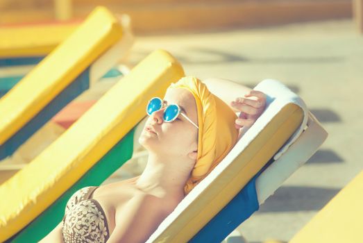 young woman sunbathing at the sea terrace . High quality photo