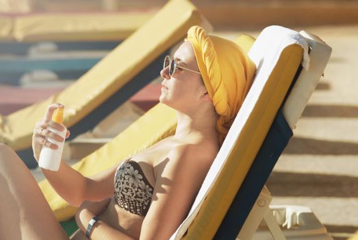 young woman sunbathing applying sun protector. High quality photo
