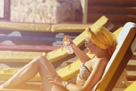 young woman sunbathing applying sun protector. High quality photo