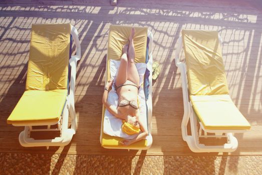 young woman sunbathing at the sea terrace . High quality photo