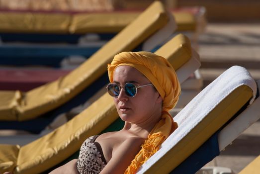 young woman sunbathing at the sea terrace . High quality photo