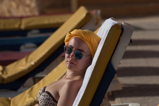 young woman sunbathing at the sea terrace . High quality photo