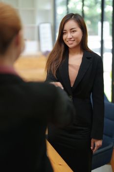 business merger, Asian businesswoman shake hands at the conference room with showcase their collaboration to strengthen their marketing efforts