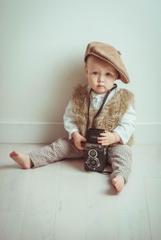 Retro styled photo with cute baby and old camera