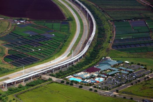 Aerial HART Rail system under construction, Highway, and Knoc Center next to each other in Kapolei city on Oahu, Hawaii.
