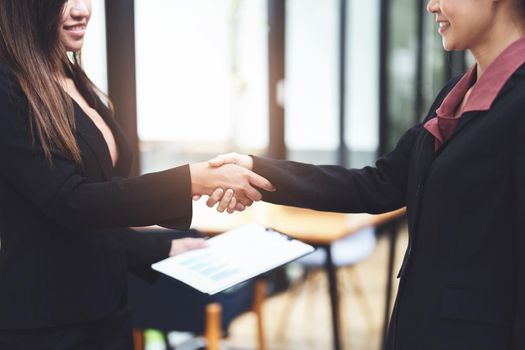 business merger, Asian businesswoman shake hands at the conference room with showcase their collaboration to strengthen their marketing efforts