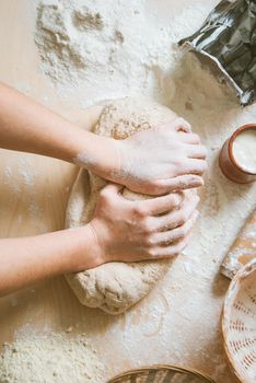 Women knead the dough from wholegrain flour and fermented yeast