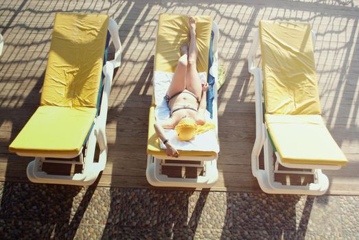 young woman sunbathing at the sea terrace . High quality photo