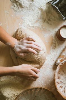 Women knead the dough from wholegrain flour and fermented yeast