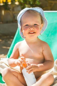 a child on the beach applies sunscreen. High quality photo