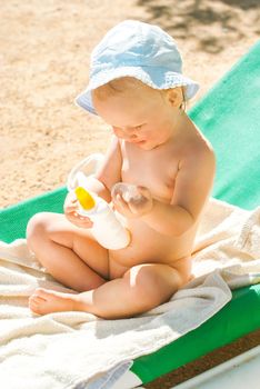 a child on the beach applies sunscreen. High quality photo