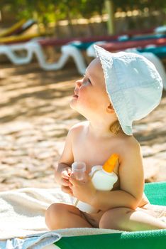 a child on the beach applies sunscreen. High quality photo