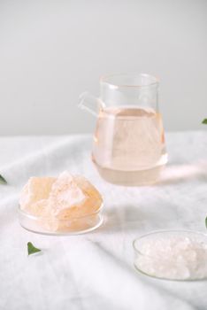 Aromatherapy. Small glass bottles with cosmetic oils. Bath salt. Fresh leaf. Objects for spa procedures on white background oil, leaf.