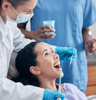 a young woman having a procedure performed by her dentist.