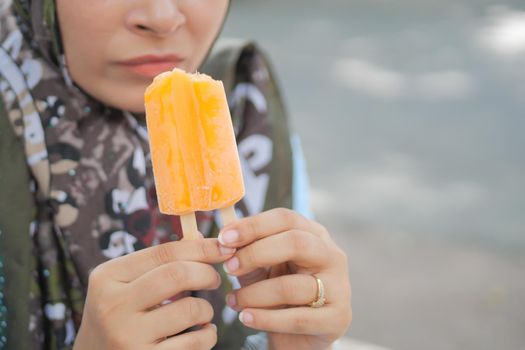 young women eating chocolate flavor ice cream .