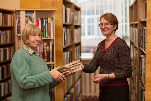 Belarus, Gomel, November 14, 2017. The main library. The librarian gives the reader books. The work of a librarian. Read books