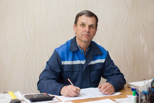 Belarus, Gomel, April 24, 2018. Reception point. Elderly employee at a table in the office.Foreman commander