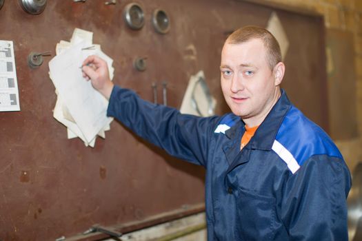 Belarus, Gomel, 25 April 2018. Factory for the manufacture of ventilation pipes.A working man is working out a plan. The plant worker writes a work plan on the work board.