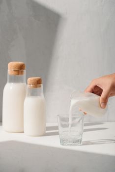 Milk from a jug pouring into glass