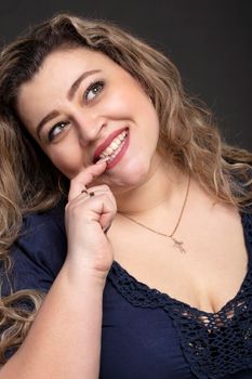 Portrait of a beautiful fat woman close-up on a gray background.