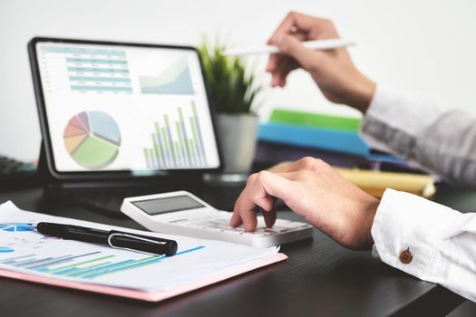 The young businessman using calculators and computers to check financial statements at home instead of working in the office.