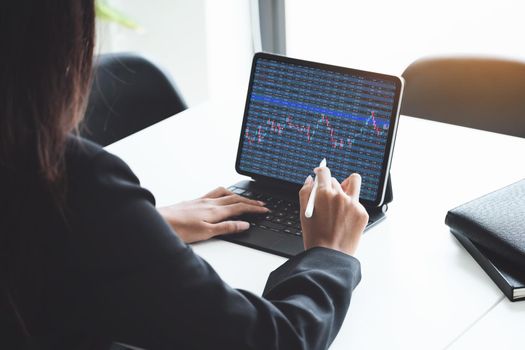 digital technology, Business woman using tablet to trade charts to find buy and sell points for her port