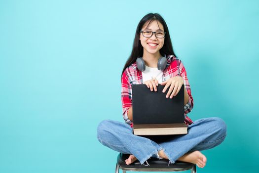 Happy Student. Cheerful Asian Girl Smiling To Camera Standing With Backpack In Studio Over Blue Background. Back to school concept.