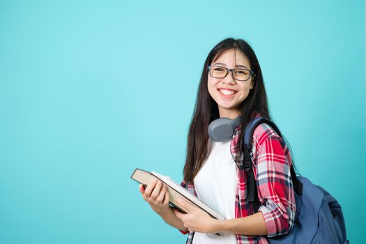 Happy Student. Cheerful Asian Girl Smiling To Camera Standing With Backpack In Studio Over Blue Background. Back to school concept.