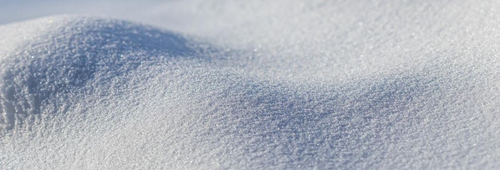 Drifts of fresh snow sparkling in the sun on a frosty day. Nature winter background.