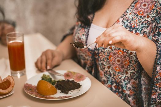 Plus Size Woman Going To Eat Healthy Food, Woman In Colorful Bathrobe Sitting At Table, Selective Focus On Female Hand Holding Fork And Picking Salad From Plate, Close Up Shot