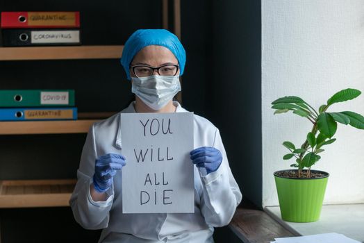 Sad Female Doctor In White Uniform Shows Inscription That Says That Everyone Will Die Due To The Epidemic Of Corona Virus, Woman In Protective Mask Looks Serious And Confident