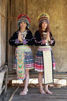 Traditionally dressed Mhong hill tribe woman pay respect at the wooden cottage