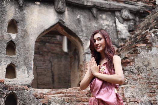 Female pay respect in Thai traditional dress at  historical park