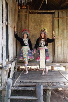 Traditionally dressed Mhong hill tribe woman in the wooden cottage